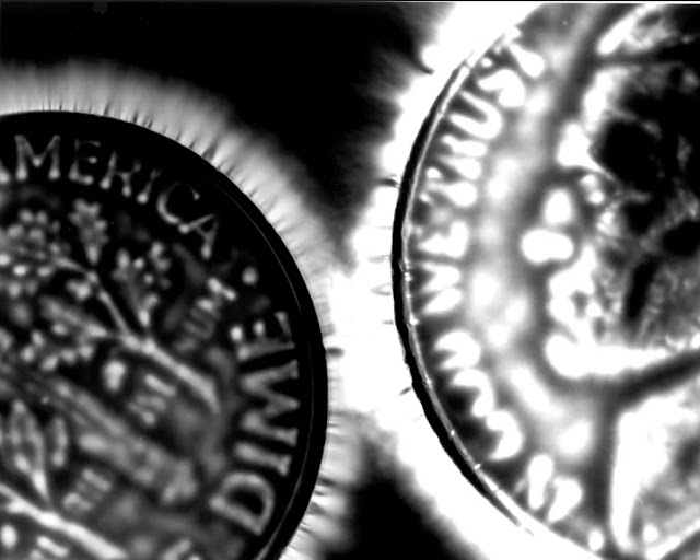 Коронный разряд на монетах, сфотографированный методом Кирлиана