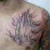 Tattoo no peito mãos que oram 