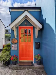 Bright orange door on a blue house in Carlingford Town