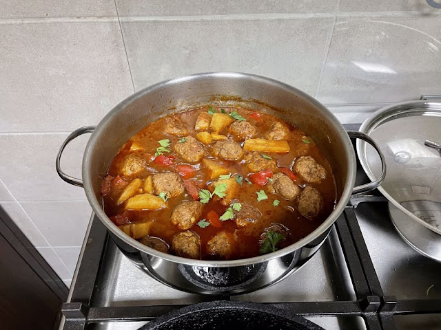 pan fried potata and peppers added to the pot of meatballs in tomato sauce