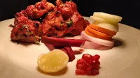 Serving Chicken Kandhari kebab, beetroot and pomegranate on side of the plate