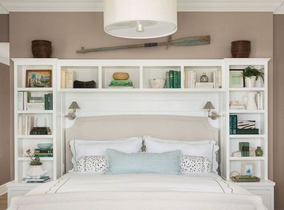 Una camera da letto con una libreria e un lampadario con su scritto la  parola.