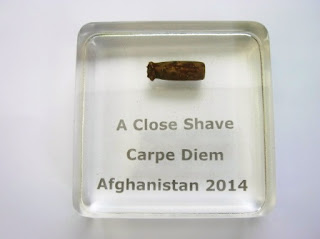 A paperweight containing a bullet that was shot at a soldier