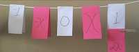 Math symbols on paper clipped to clothesline