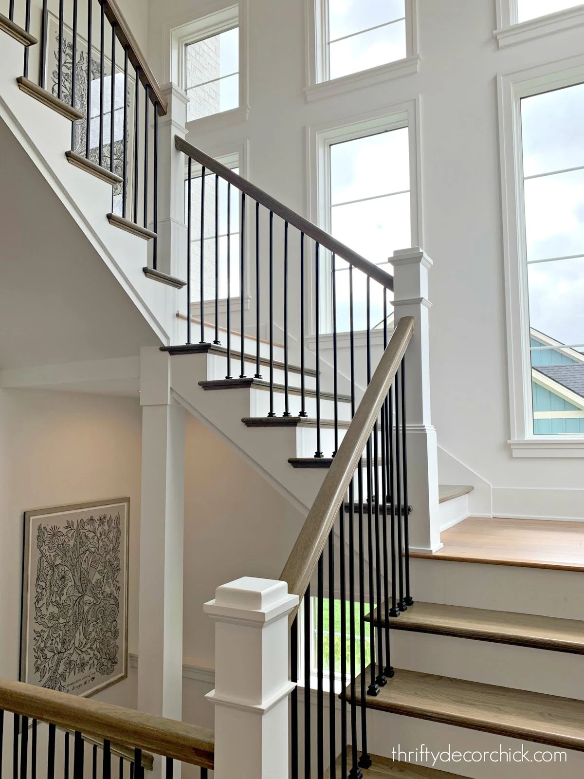 Open staircase with windows and black spindles