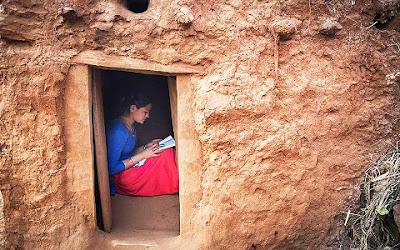 NYTimes: Kusum Thapa, 17, doing her schoolwork in a chhaupadi hut. In areas of Nepal, women and girls are banished to such huts when they are menstruating. Picture/तस्वीर