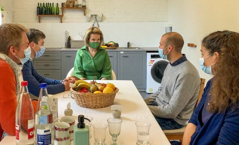 Queen Mathilde wore a green belted shirt dress from Natan, and she carries Fabienne Delvigne cluth bag