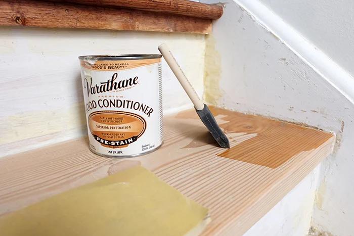 applying wood conditioner to pine wood