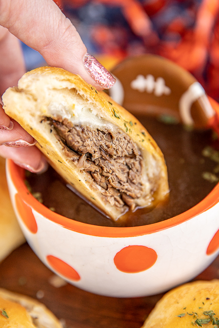 French Dip Biscuits Recipe - refrigerated biscuits, stuffed with roast beef, provolone, horseradish, and baked. Brush with melted butter when they are hot. Serve with a side of hot au jus. SO good! Great for parties, tailgating, lunch or dinner. These are always a hit! #sandwich #roastbeef #frenchdip #biscuit dipping sandwich in au jus