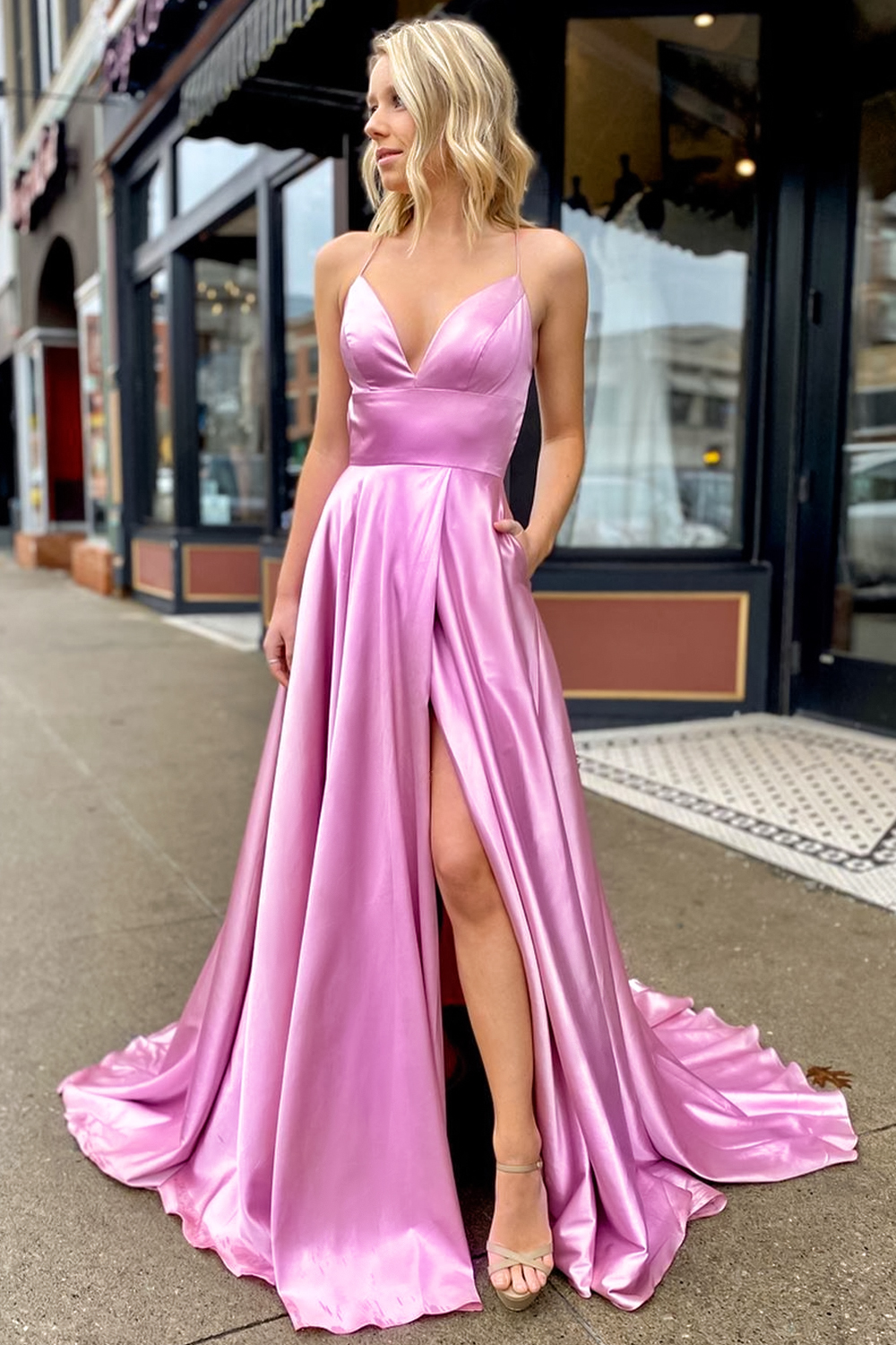 bridesmaid is posing on a street in a beautiful dress
