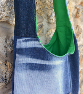 Sac bandoulière fait de pans de pantalons en jeans recyclés (chinés par mes soins), de différents tons, montés façon patchwork, coutures surpiquées de fil vert, bandoulière en jeans, entièrement doublé en tissu coton vert prairie, poche en jeans cousue sur l'extérieur. Les jeans portés recyclés parfois délavés par le temps apportent cette "petite chose en plus" à cette pièce unique. Dimensions : 35 x 33 x 8 cm, hauteur avec la bandoulière : 83 cm.