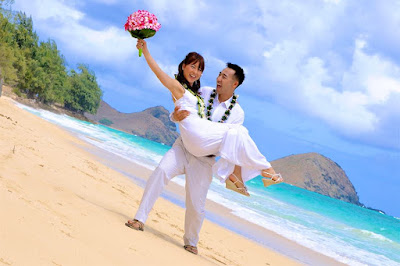 Hawaii beach wedding with groom holding the bride with a smile