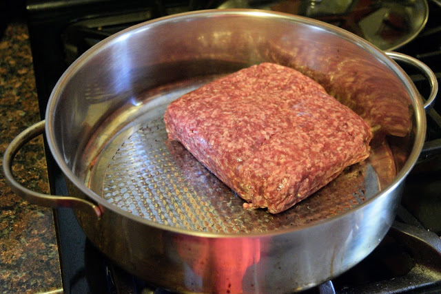 Ground beef in the skillet, on the stove.