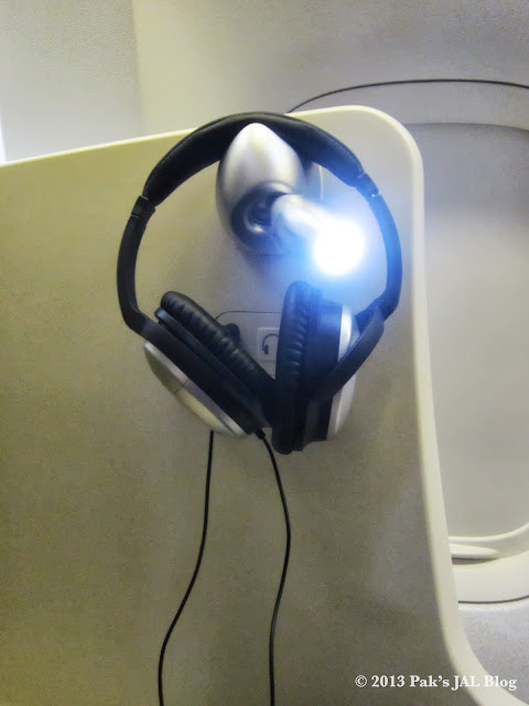 The reading light on the non-aisle side doubles as the headset holder