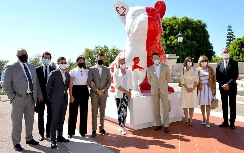 Princess Stephanie, Louis and Marie Ducruet at the inauguration of the sculpture of Doggy John. White jacket, striped pants, red bag