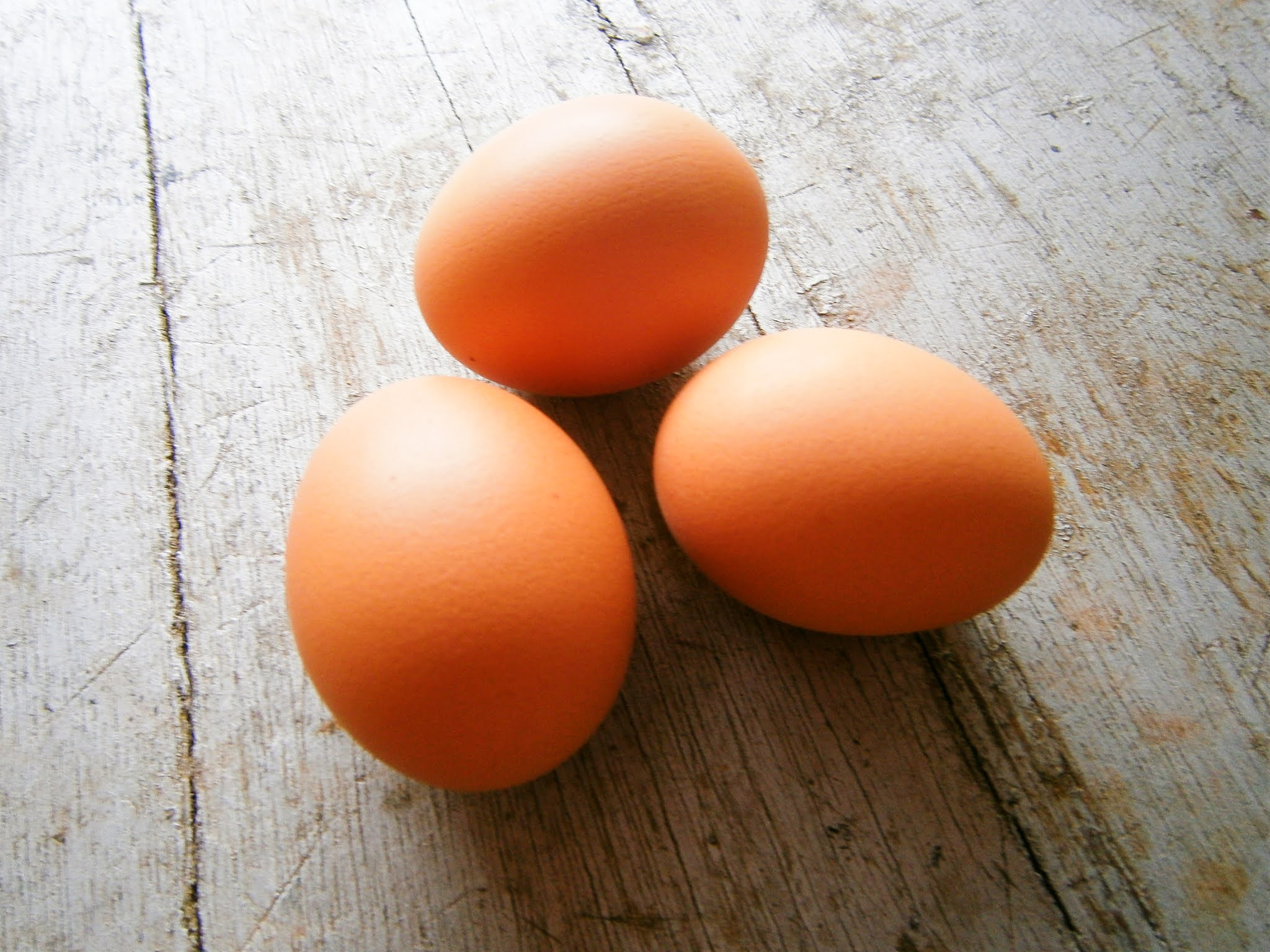 Huevos de gallina puestos sobre la superficie de una madera de color plomo