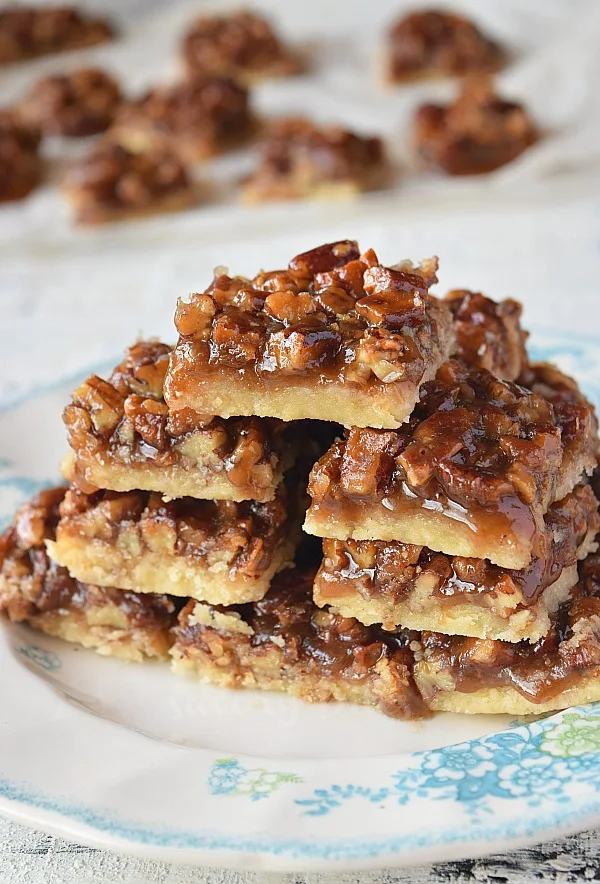 a white plate with delicious easy pecan pie bars piled up