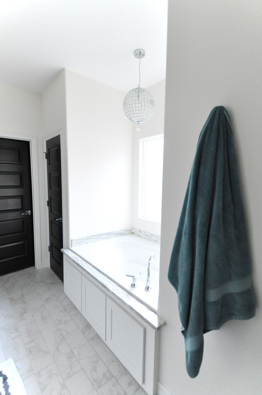Black interior doors and white wall create a luxe and dramatic master bathroom retreat.