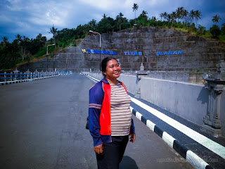 Woman Traveling On The Road Above The Large Dam Of Titab Ularan In The Sunny Cloudy Day Of Dry Season North Bali Indonesia
