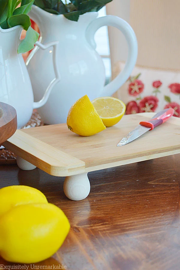 Raised Cutting Board on table with cut lemons on top