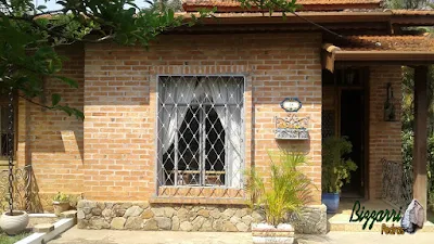 Casa com base de pedra, tipo revestimento de pedra com chapas de pedra moledo em casa com parede de tijolo a vista em condomínio em Atibaia-SP.