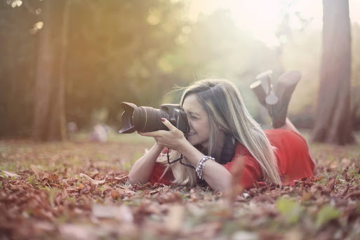 girl taking photograph in nature