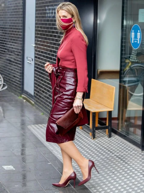 Queen Maxima wore a red wool coat from Natan, and burgundy leather skirt and silk blouse from Natan