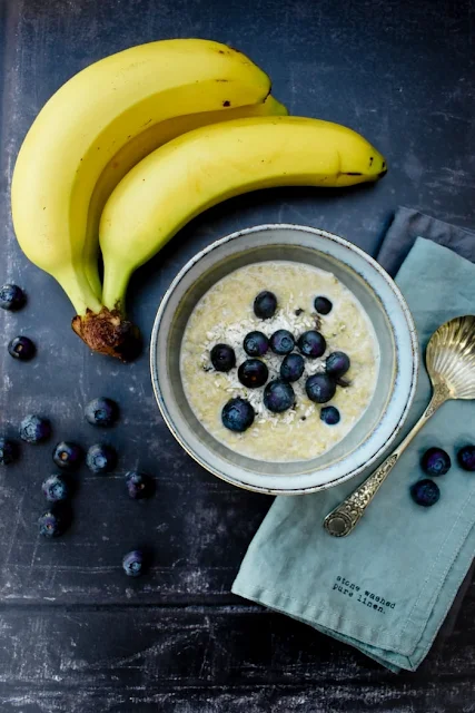 Creamy Blueberry, Banana and Coconut Porridge in a bowl topped with fresh blueberries