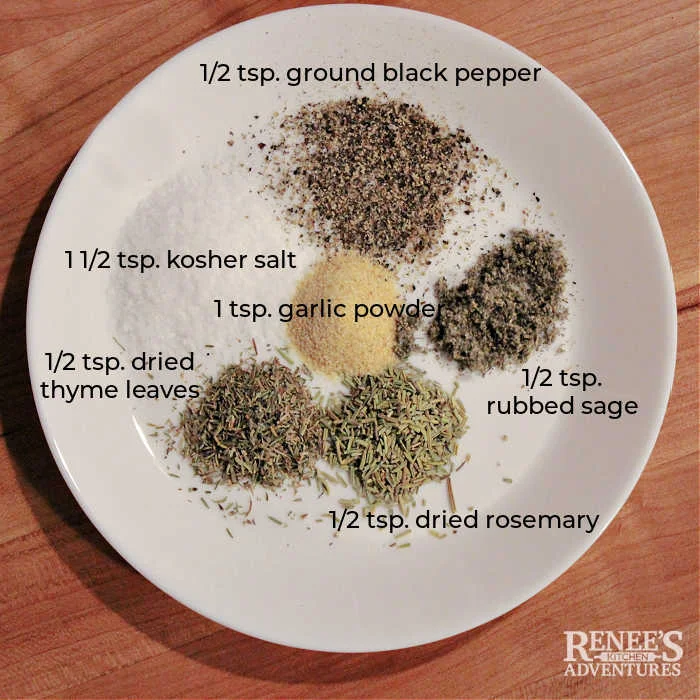 Overhead shot of white plate with herbs and spices needed for seasoning pork ribeye roast