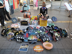 two artists wearing respiratory masks spray painting vinyl records