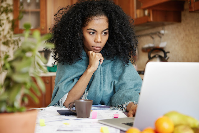 Beautiful black woman sitting in front of her computer. Image of Beautiful black woman sitting in front of her computer.