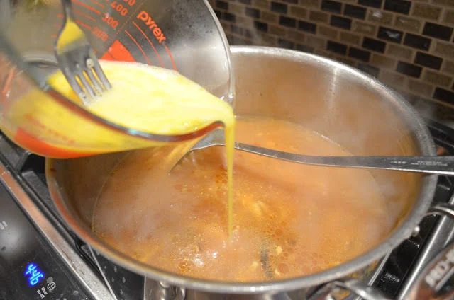 Egg mixture slowly being poured into Hot and Sour Chicken Soup.