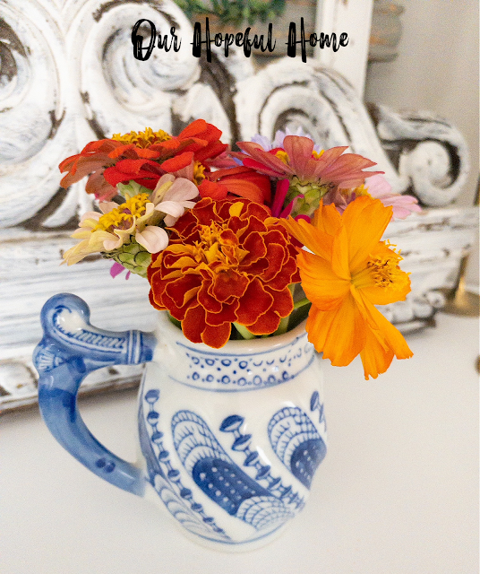 blue white chinoiserie creamer filled with marigolds
