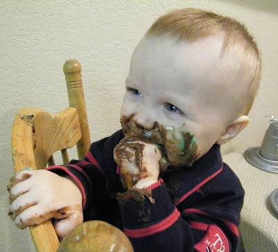 baby eating messy chocolate cake