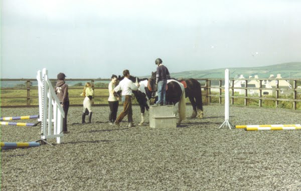 Training an der Arena. Eng eschten Ke'er op een Perd klammen. Net esou einfach