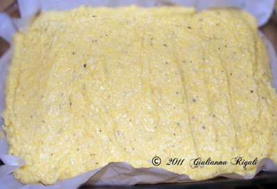 Spreading the cooked polenta in the pan to refrigerate for cutting.