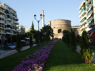 more Thessaloniki, normal homes on both sides, beautiful flowers in the middle and ancient ruin a bit higher
