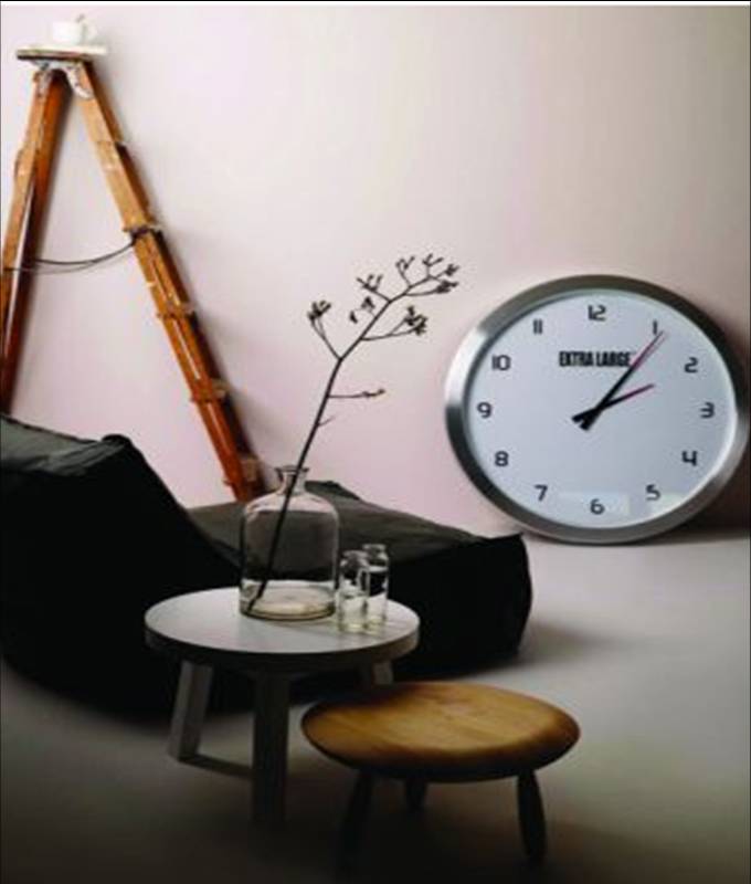 Sitting room with a large clock on the ground, a ladder, round side table and black chaise lounge