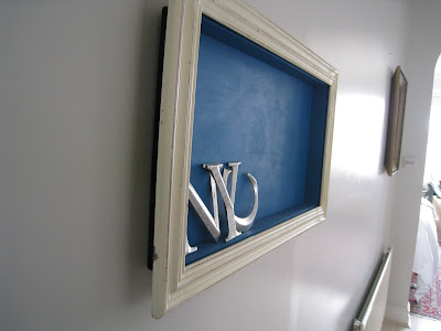 Side view of a shadow box made by Shannon Cockrell hung on a wall in her London flat