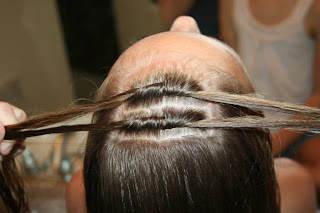 Top view of young girl's hair being styled into "Knots into Side Ponytail" hairstyle