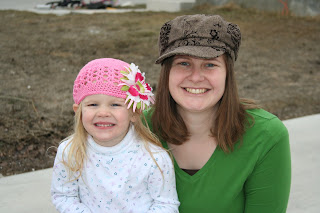 Portrait of young girl and her mother modeling giveaway prizes of hats