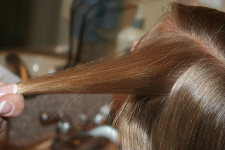 Side view of young girl's hair being styled into "Beachy Combo" hairstyle