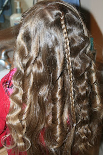 Back view of young girl's hair being styled into "Beachy Combo" hairstyle 