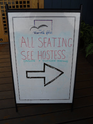 Sandwich board: Please see hostess for indoor / outdoor seating. (Marina Side Grill, North Vancouver, BC)