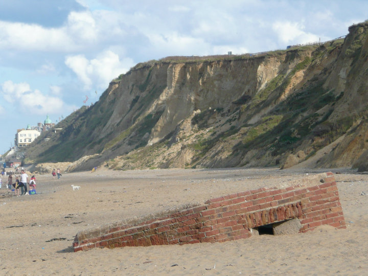 An old Pillbox lies sunken in the sands close to Cromer