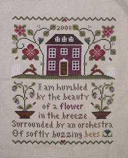 cross stitch sample of house and flowers with verse