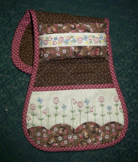 pink and brown arm chair sewing caddy for guild's sale table at the quilt show