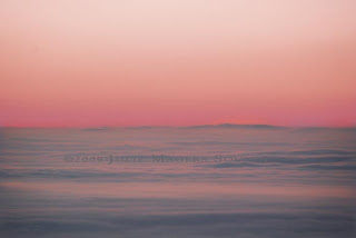 A blanket of fog rests silently over the High Plains of Colorado as the sunrise turns pink