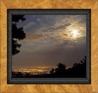 Framed photo of the autumnal full moon rises over the city of Fort Collins on the high plains of Colorado casting a glowing blush in the sky of pink, mauve, and lavender.