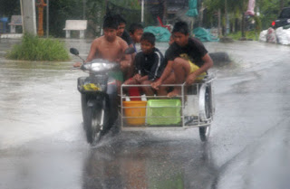6 wet kids on a bike with sidecar